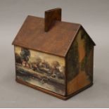 A wooden house form money box. 14 cm wide.