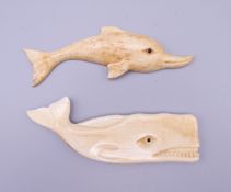 A carved bone model of a whale and a carved bone model of a dolphin. The former 8 cm long.