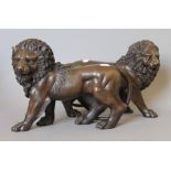 A pair of bronze models of lions. 31 cm long.