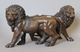 A pair of bronze models of lions. 31 cm long.