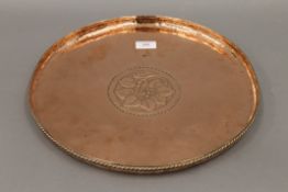 A Hugh Wallis Arts and Crafts copper charger. 38 cm diameter.