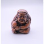 A Japanese netsuke formed as a seated man. 4 cm high.