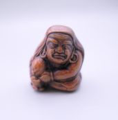 A Japanese netsuke formed as a seated man. 4 cm high.