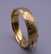 A 1/5th 9 ct gold engraved bracelet. 6.5 cm wide. 31 grammes.
