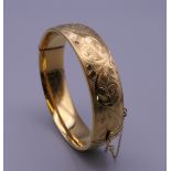 A 1/5th 9 ct gold engraved bracelet. 6.5 cm wide. 31 grammes.