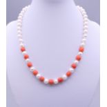 A pearl and coral bead necklace with a 14 ct gold clasp. 40 cm long.