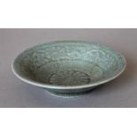 A small Chinese celadon bowl, the underside decorated with calligraphy. 14 cm diameter.