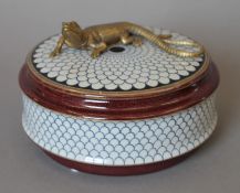 A porcelain box mounted with a lizard. 14 cm diameter.