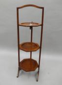 An Edwardian mahogany folding cake stand.