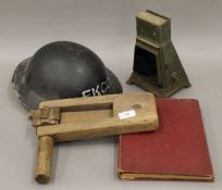 A First Aid book, together with a lamp, rattle and a First Aid Ekco helmet.