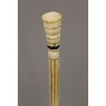 A 19th century carved whalebone walking stick with carved ivory handle. 83 cm long.