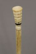 A 19th century carved whalebone walking stick with carved ivory handle. 83 cm long.