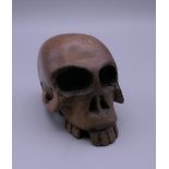 A carved wooden netsuke formed as a skull. 4 cm high.