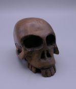 A carved wooden netsuke formed as a skull. 4 cm high.