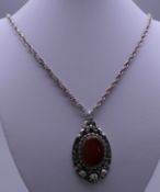 A German silver pendant set with agate, on chain. The pendant 5 cm high.