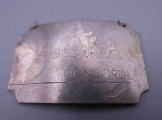 A Concorde silver decanter label. 12.2 grammes.