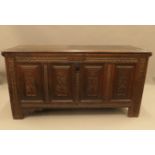 An 18th century carved four panel oak coffer. 146 cm long.