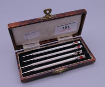 A cased set of four sterling silver bridge pencils.