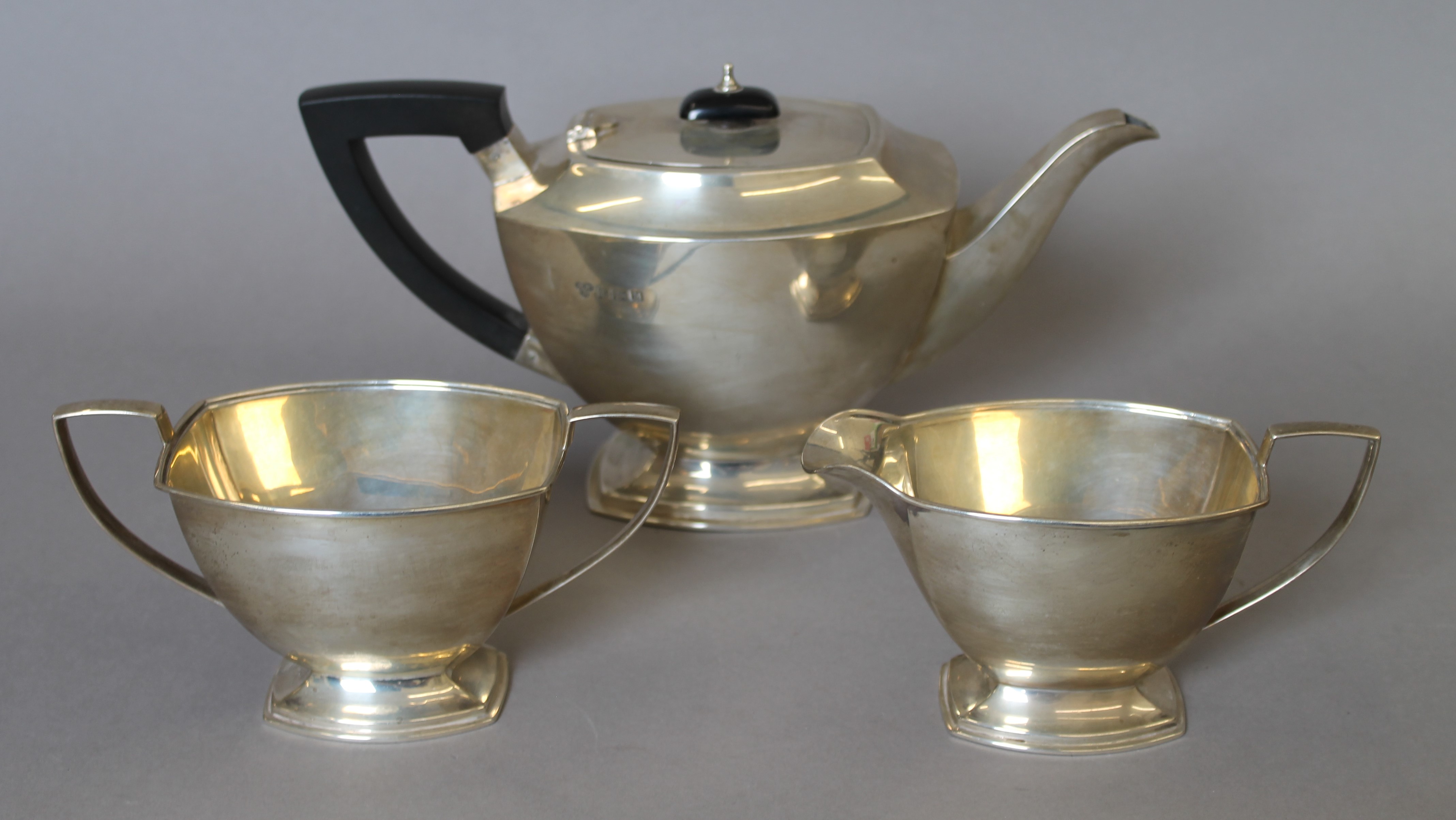 A silver three-piece tea set. The teapot 28 cm long. 933.6 grammes total weight.