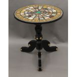 A gilt heightened ebonised tripod table with circular marble and specimen stone top. 63.