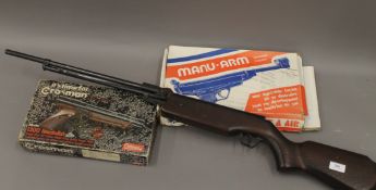 A Crosman boxed air pistol, a French boxed air pistol and an air rifle. The latter 110 cm long.