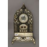 An unmarked white metal mantle clock. 49 cm high.