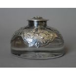 A silver mounted inkwell embossed with cherubs. 6 cm high.