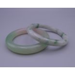 Two jade bangles. Each approximately 7.5 cm exterior diameter.