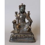 A bronze model of Buddha seated astride a dog-of-fo. 22 cm high.
