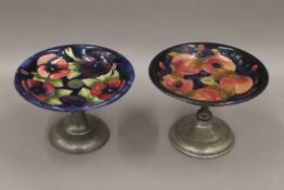 A Moorcroft tazza with beaten pewter base, together with another similar. The former 14.5 cm high.