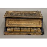 A 19th century paper covered miniature piano. 24 cm wide.