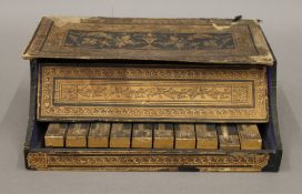 A 19th century paper covered miniature piano. 24 cm wide.