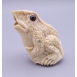 A carved bone model of a frog. 5 cm high.