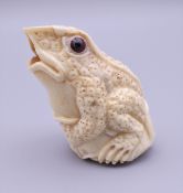 A carved bone model of a frog. 5 cm high.