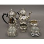 A silver plated tea set and a set of coasters.
