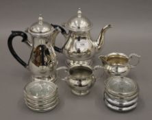 A silver plated tea set and a set of coasters.