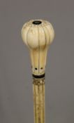 A 19th century carved whalebone walking stick with carved ivory handle. 91 cm long.