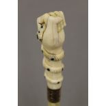 A 19th century whalebone walking stick with carved ivory clenched fist and snake handle,