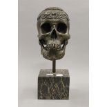 A bronze skull on a marble base. 35 cm high.