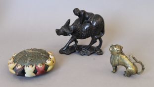 A Chinese white metal inlaid wooden model of a boy on a buffalo,