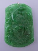 A carved jade pendant with gold suspension loop. 6.5 cm high.