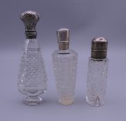 Three French silver topped scent bottles. 8 cm high, 8.75 cm high and 11 cm high respectively.