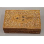 A set of bone and ebony dominoes in an Eastern carved box. The box 20 cm wide.