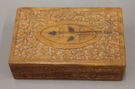 A set of bone and ebony dominoes in an Eastern carved box. The box 20 cm wide.