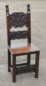 A Jacobean style carved walnut solid seated chair. 123 cm high.