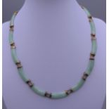 A gold and jade necklace. 42 cm long.