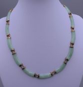 A gold and jade necklace. 42 cm long.