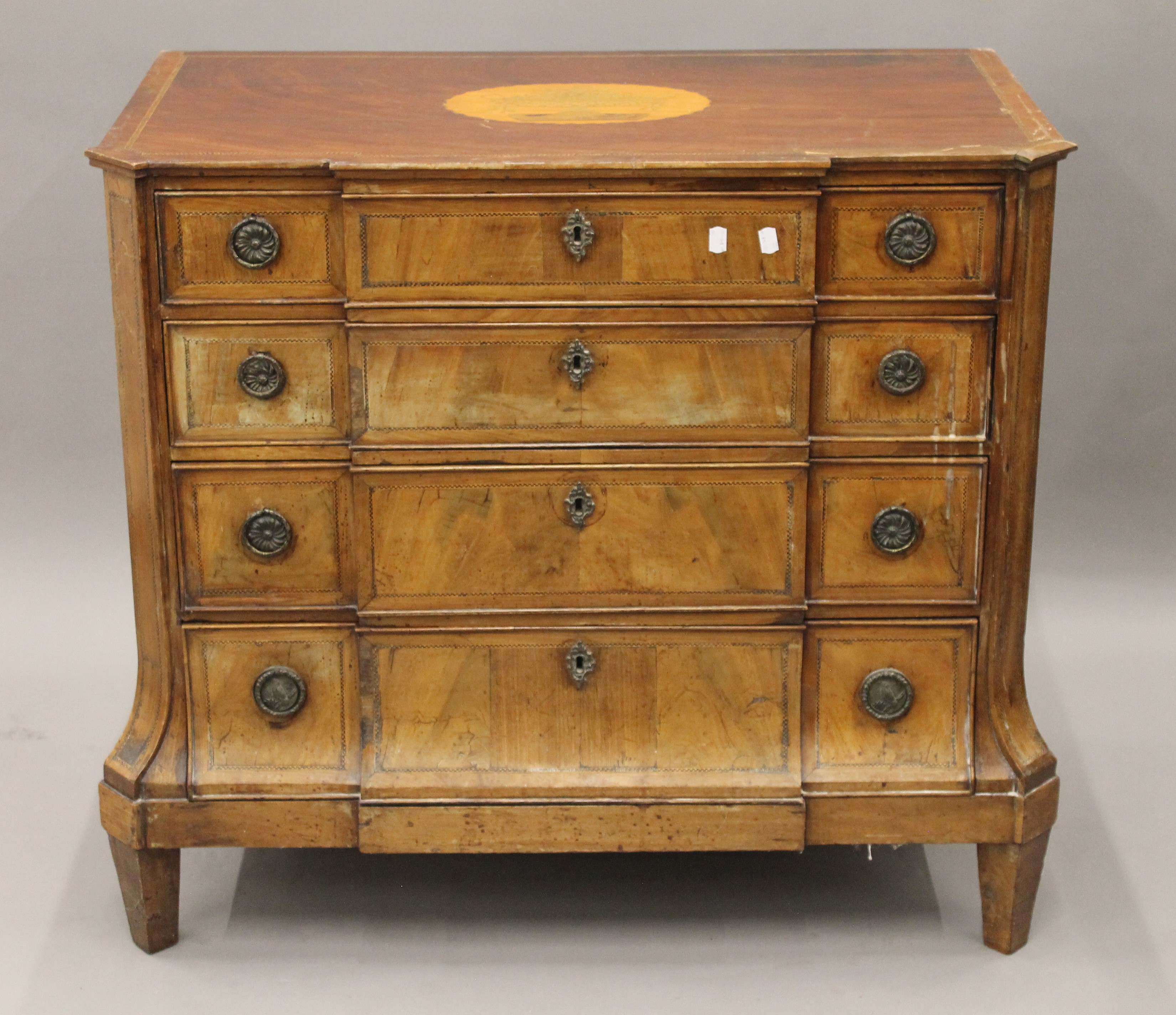 A 19th century inlaid mahogany breakfront chest of drawers. 96.5 cm wide.