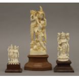 An early 20th century Indian carved ivory figural group and two smaller examples.