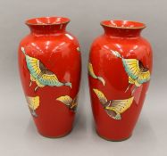 A pair of red ground porcelain vases decorated with butterflies. 35 cm high.